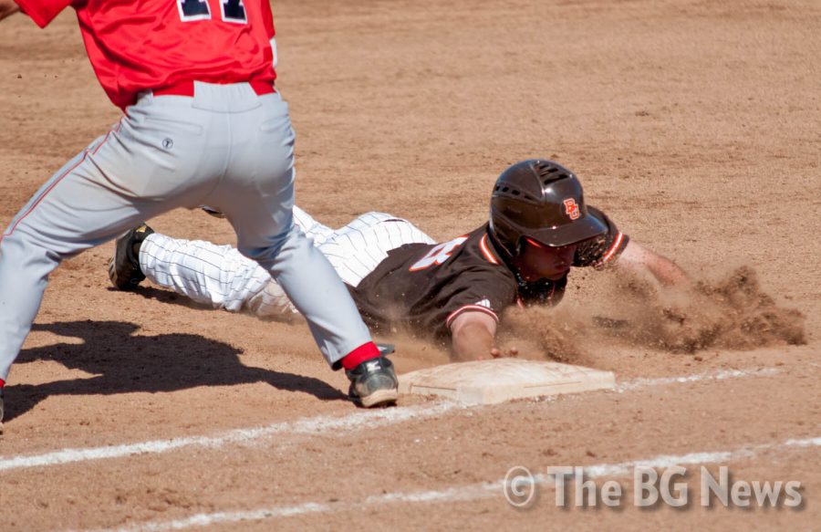 Jake Thomas, BG outfielder, dives back into first base during the Falcons’ 24-11 victory against Malone earlier this season.
