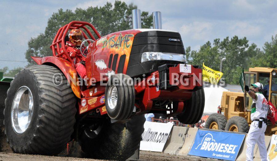 Larry Phillips, of Vine Grove, Kentucky, celebrates his win in
the 6,200-pound Light Super Stock class at the National Tractor
Pulling Championship at the Wood County Fairgrounds this past
weekend. Phillips won despite his front steering linkage breaking
before the start of his run.