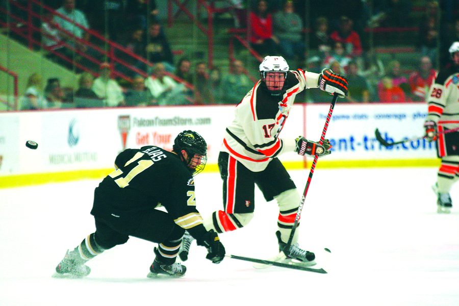 Ben Murphy, BG forward, chips the puck around Western Michigan forward Trevor Elias during the Falcons 2-2 tie with the Broncos earlier this season.