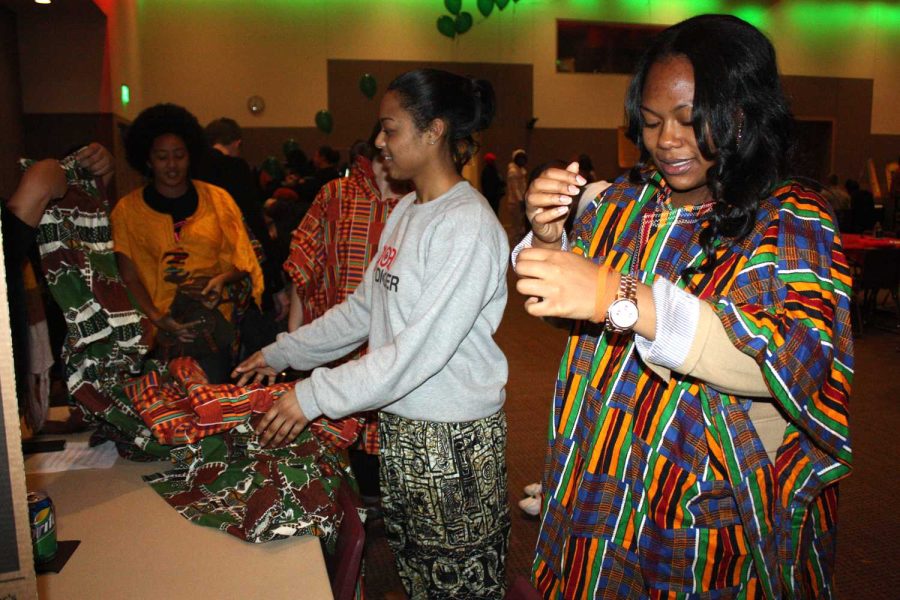 Students at the Kwanzaa festival in Olscamp on Tuesday night try on clothing they had available to celebrate their heritage.