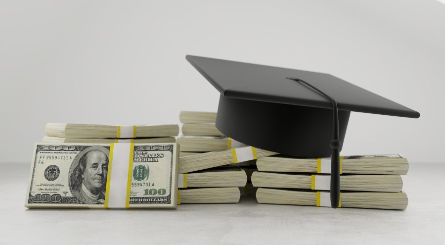 Stack of money with graduation cap on top