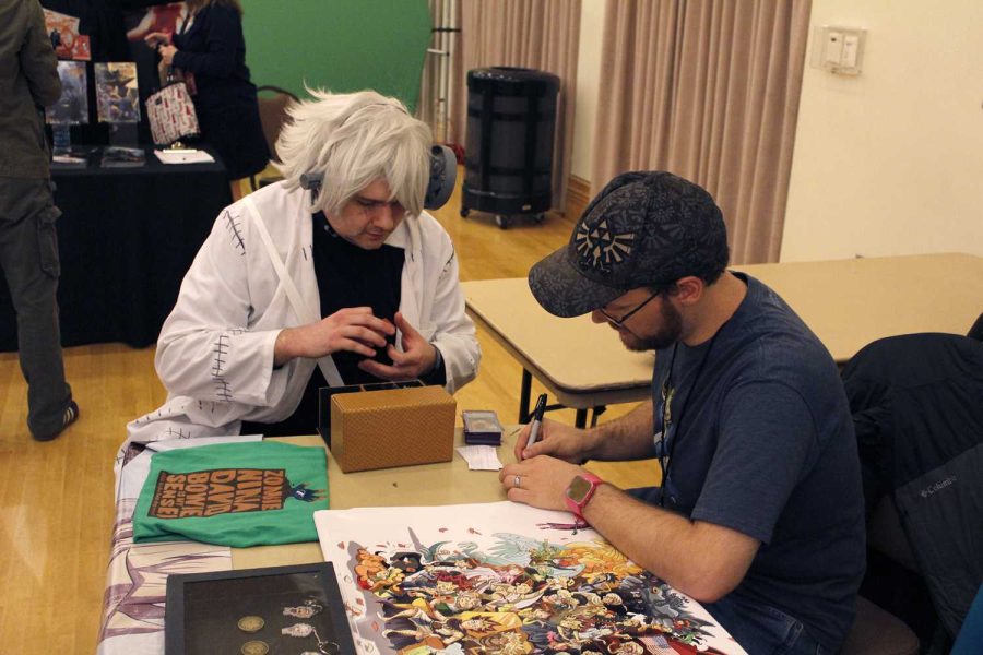 Martin "Little Kuriboh" Billany (right), creator of Yu-Gi-Oh abridged, signs a Yu-Gi-Oh card for Thomas Arthur, who is dressed as Dr. Stein from Soul Eater.