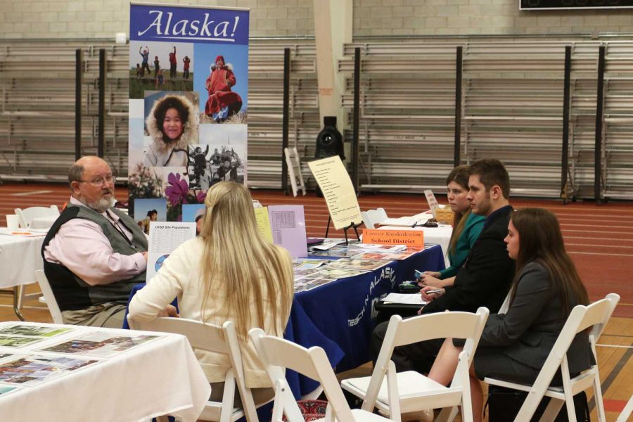 Mike Smit, Teacher Principal Recruiter, talks to a group of students about working in Alaska during the teaching job fair.