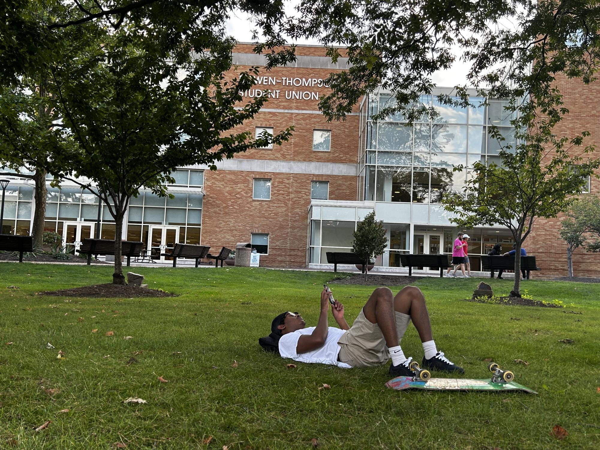 BGSU student Simon Eigon cooling off in front of the Bowen-Thompson Student Union. 
