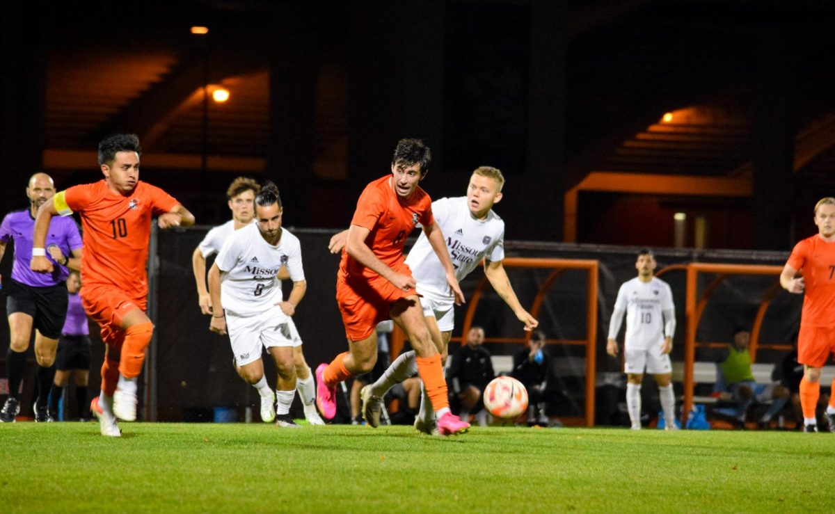  Andrew Shaffer (#8) and Alberto Anaya (#10) running up field.