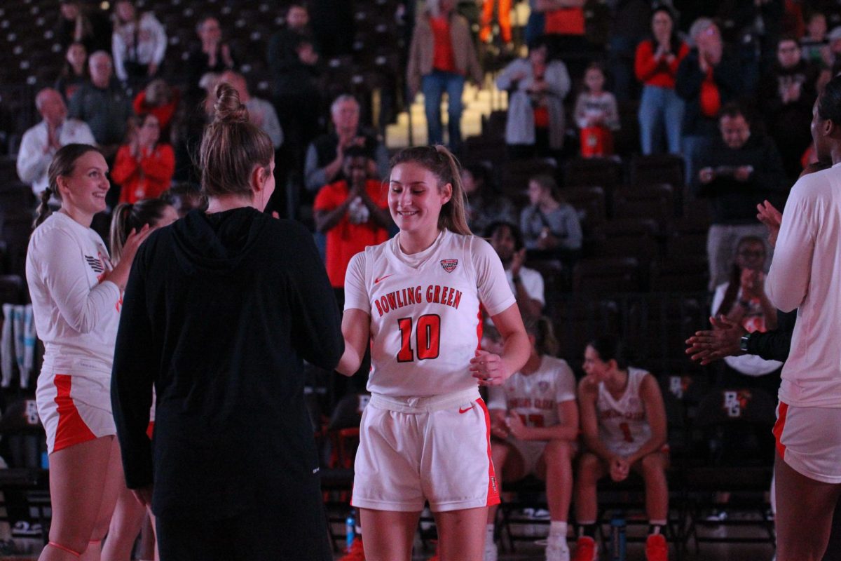 Paige Kohler (10) doing a handshake with Morgan Sharps (0) during player introductions.