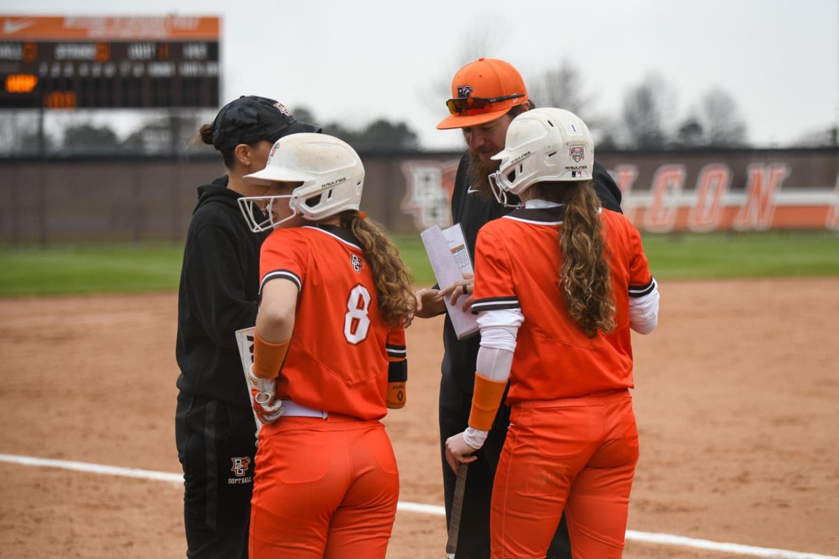 Bowling Green, OH - Game 1 Falcons sophomore outfielder Delaney Davies (8) and sophomore second base Wynnie Reid (1) discussing the play with their coaches as they get ready to take the plate at Meserve Field in Bowling Green, Ohio