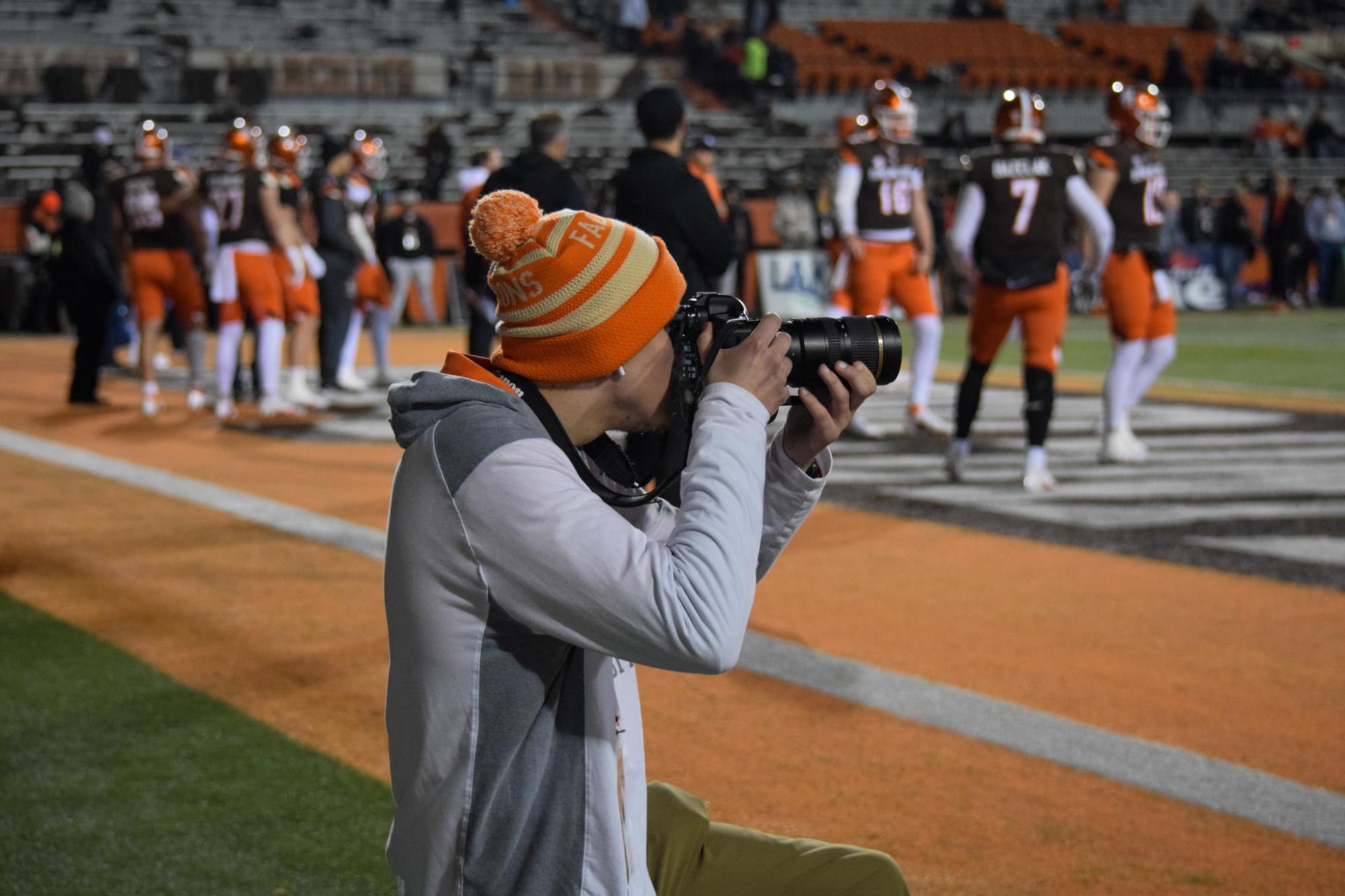 Drake Harlett, photographer for BG Falcon Media shooting a football game. 