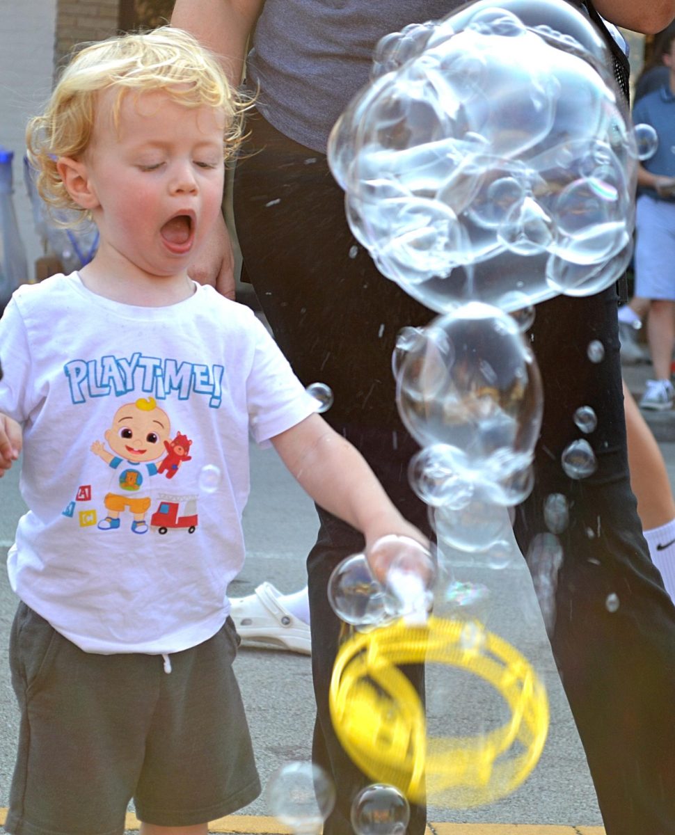 A young Firefly Night attendee takes advantage of free bubbles on Main Street.