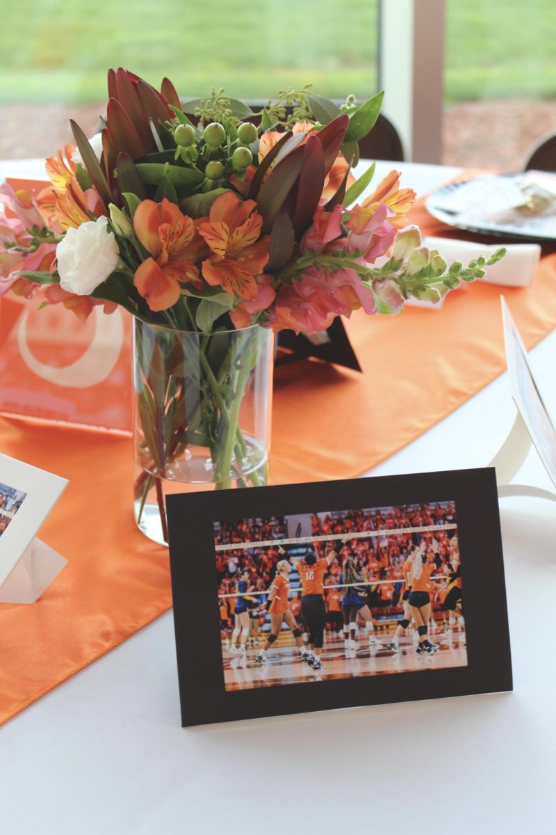 Table centerpieces with action photos from past games and floral arrangements