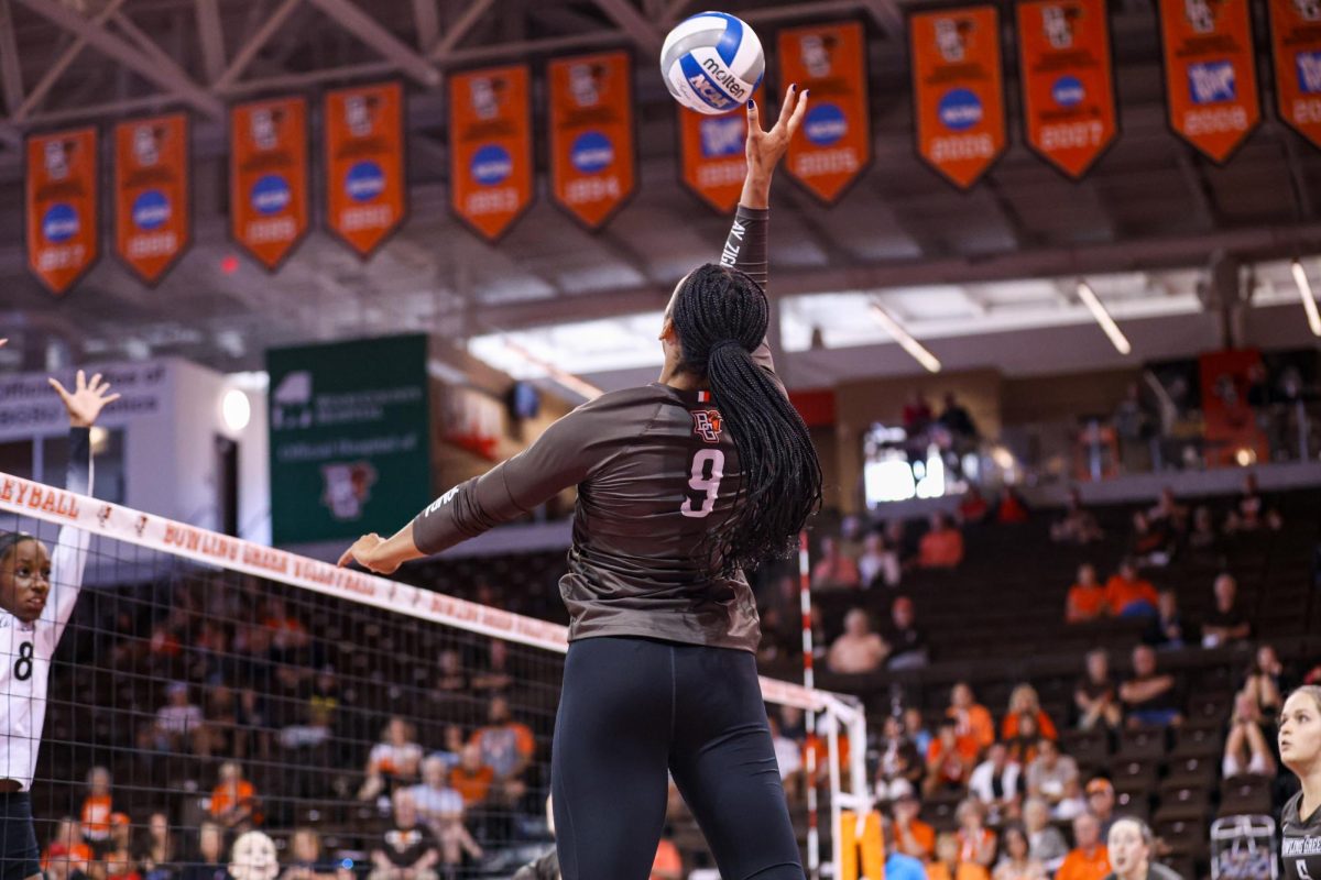 Bowling Green, OH - Falcons senior outside Hitter Mia Tyler (9) goes up to hit the ball against the Bearcats blockers at the Stroh Center in Bowling Green, Ohio.