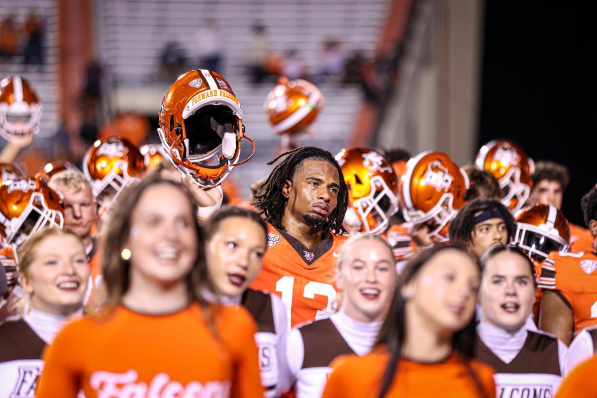 Bowling Green, OH - Falcons Senior outside linebacker Charles Rosser (13) raises his helmet during the BGSU Alma Mater at Doyt L. Perry Stadium in Bowling Green, Ohio.