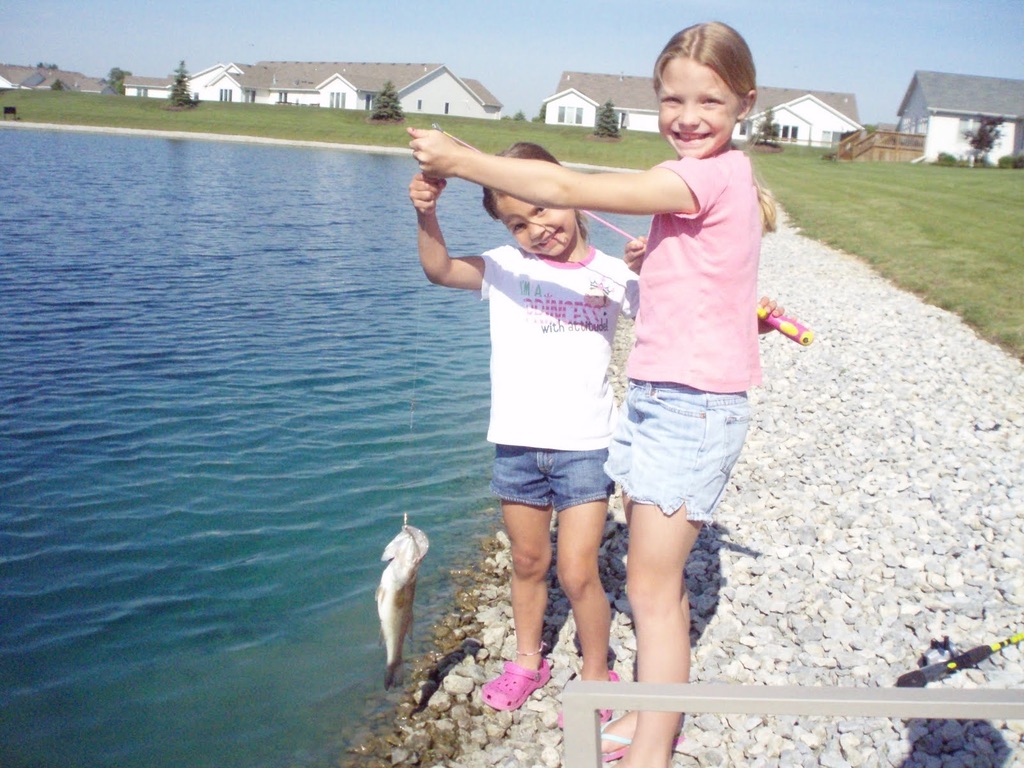 Brynn (left) and Emilie (right)  as kids proudly showing off their catch