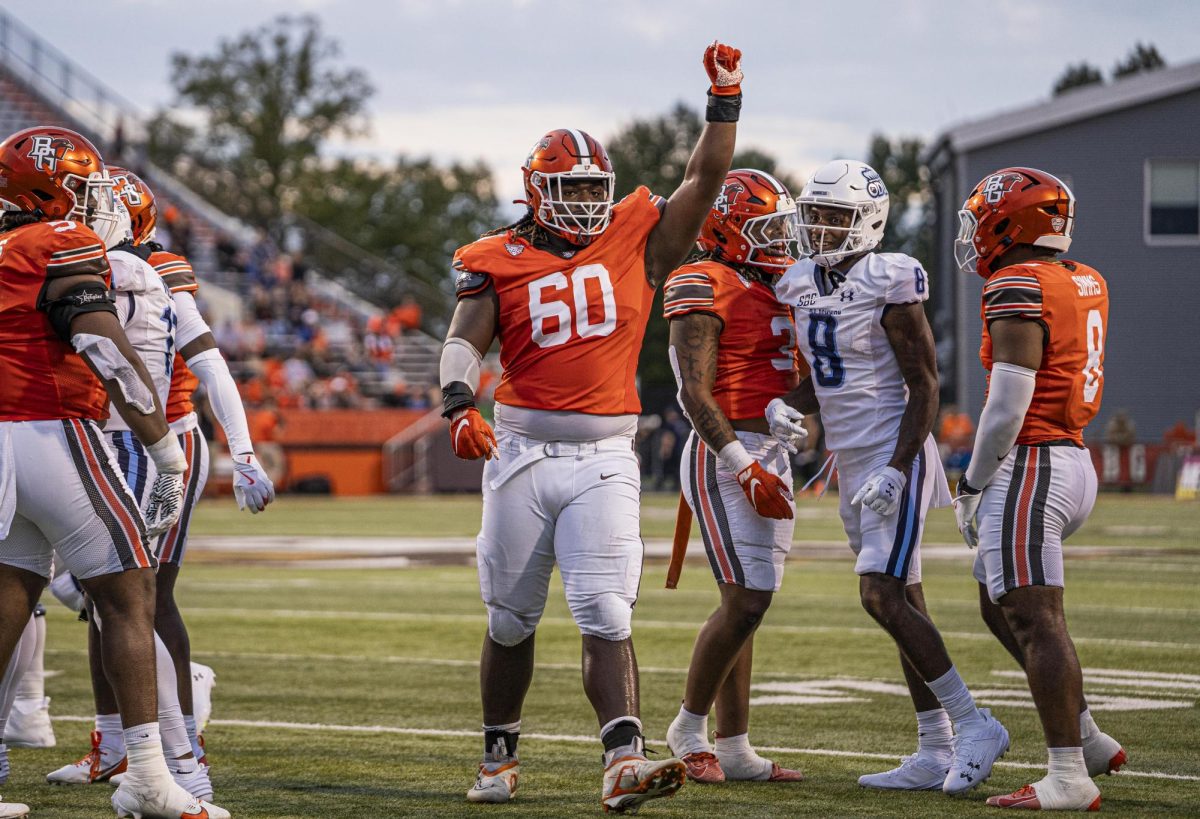 Bowling Green, OH – Falcons senior defensive lineman Dontre Brown (60) signals a defensive stop to the BGSU fans at Doyt L. Perry Stadium in Bowling Green, Ohio