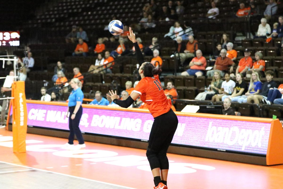 Bowling Green, OH - Falcons sophomore setter Amanda Otten (11) serves the ball after a point against Western Michigan at the Stroh Center in Bowling Green, Ohio.