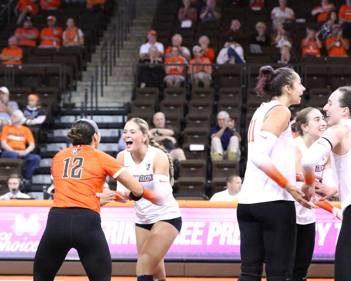 Bowling Green, OH- Falcons Graduate Defensive Specialist Lindsey LaPinta (12) and Freshamn Defensive Specialist Avery Anders (3) high-five after one of the final points in the first set at the Stroh Center in Bowling Green, Ohio.