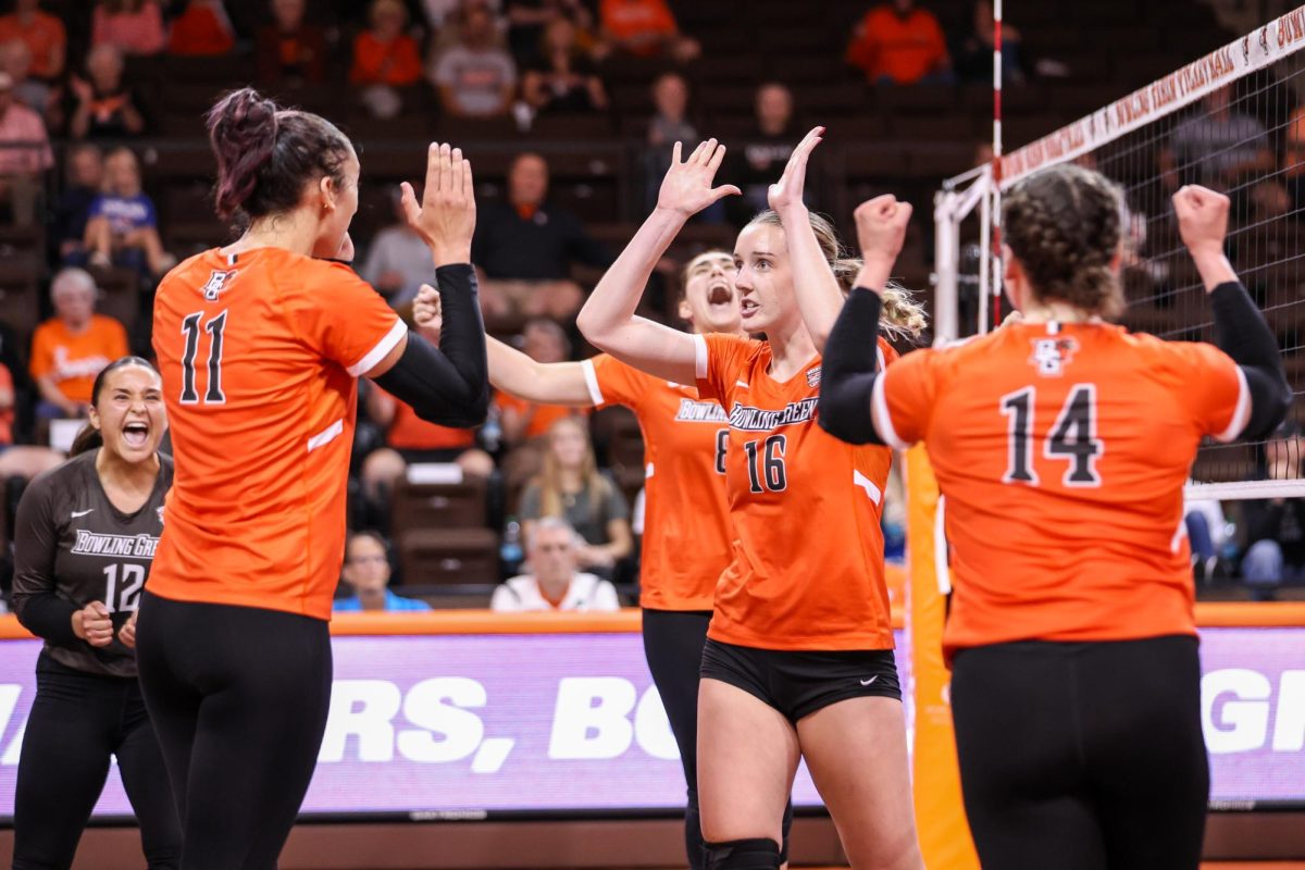 Bowling Green, OH - 5th year middle blocker Alexis Mettille (16) high-fives sophomore setter Amanda Otten (11) during a match against Western Michigan at the Stroh Center in Bowling Green, Ohio.