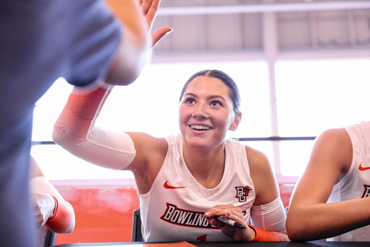 Bowling Green, OH - Falcons Freshman defensive specialist Sydnie Hernandez (1) high-fives a young fan during an autograph signing event following a match against Western Michigan at the Stroh Center in Bowling Green, Ohio.