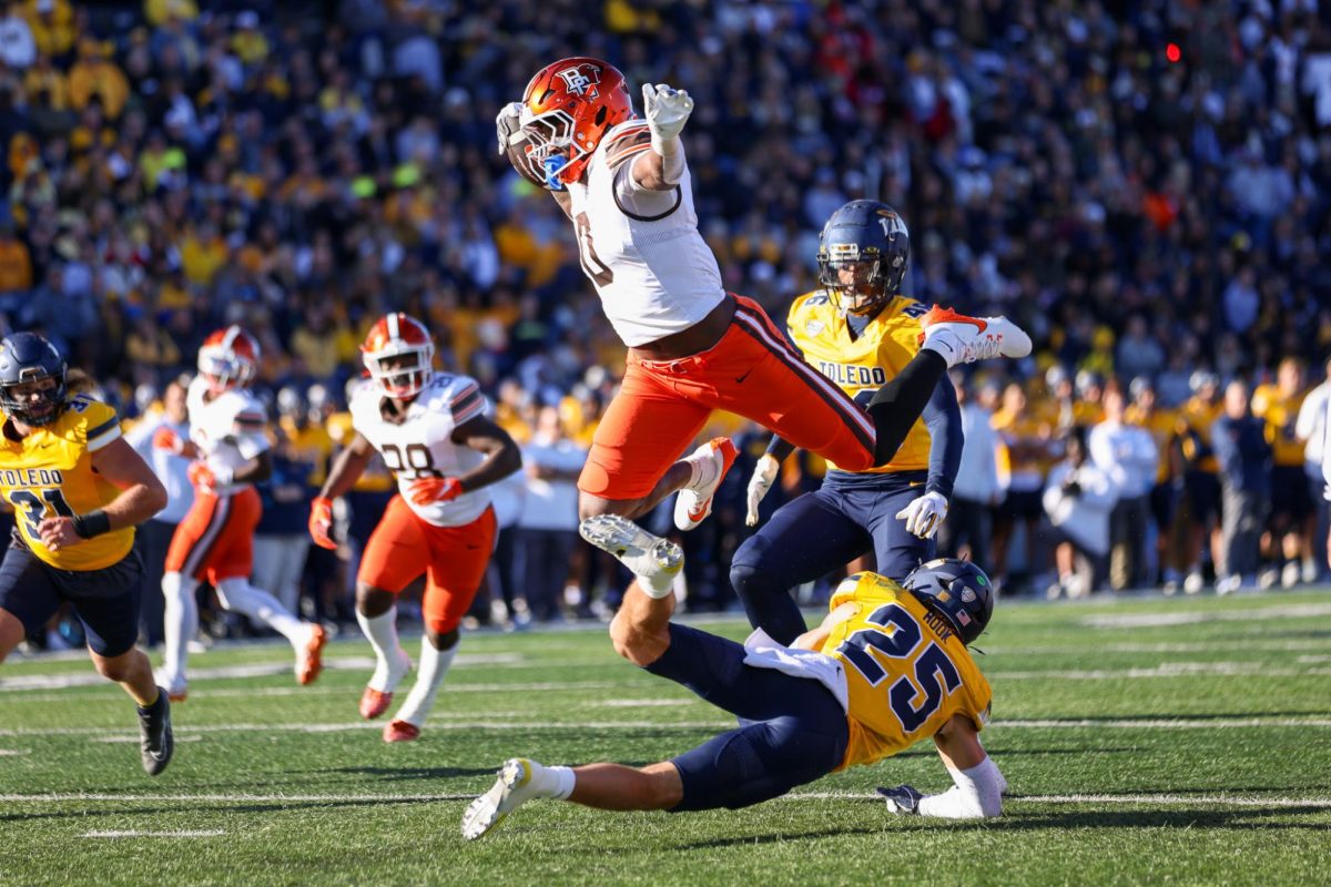 Toledo, OH - Falcons junior tight end Harold Fannin Jr. (0) jumps over a knocked down Toledo defender into the end zone at the Glass Bowl in Toledo, Ohio