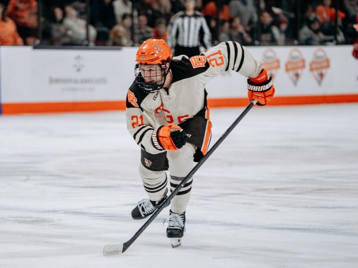 Bowling Green, OH – Falcons graduate forward Seth Fyten (21) skating to the puck at Slater Family Ice Arena in Bowling Green, Ohio.