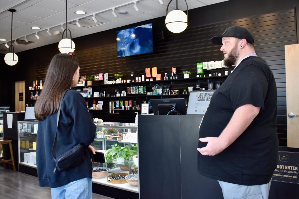 Claire Sant and Zach Gergich discussing  the dispensary