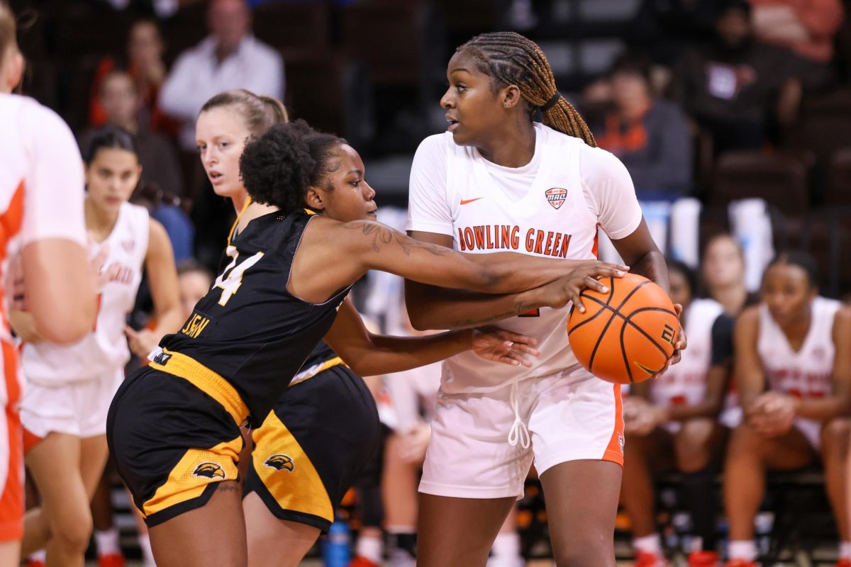 Bowling Green, OH - Eagles senior guard Nyla Jean (14) reaches for the ball held by Falcons sophomore forward Taya Ellis (11) at the Stroh Center in Bowling Green, Ohio.