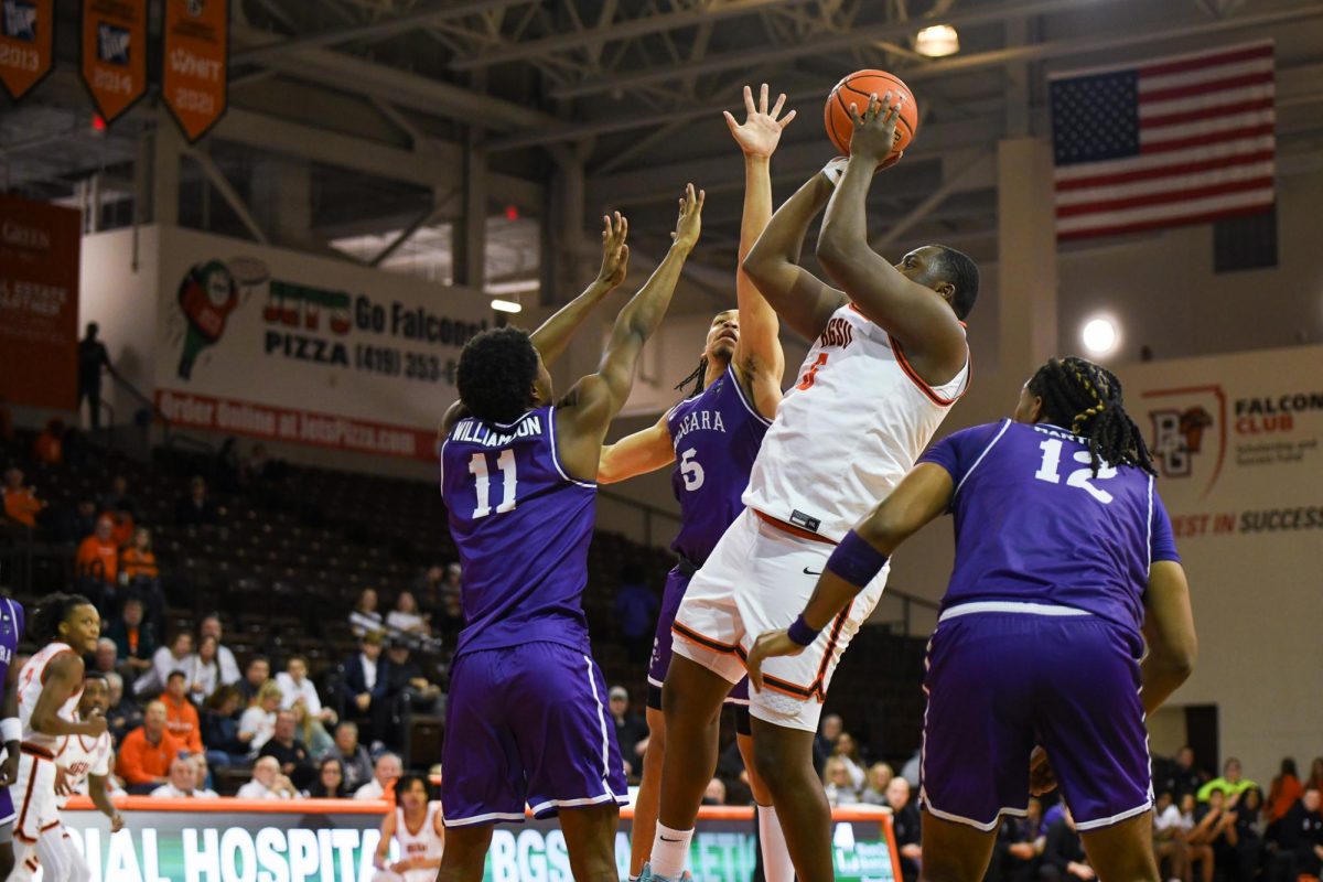 Bowling Green, OH - Falcons senior forward Marcus Johnson (6) taking a fade way with three Purple Eagles around him at the Stroh Center in Bowling Green, Ohio.