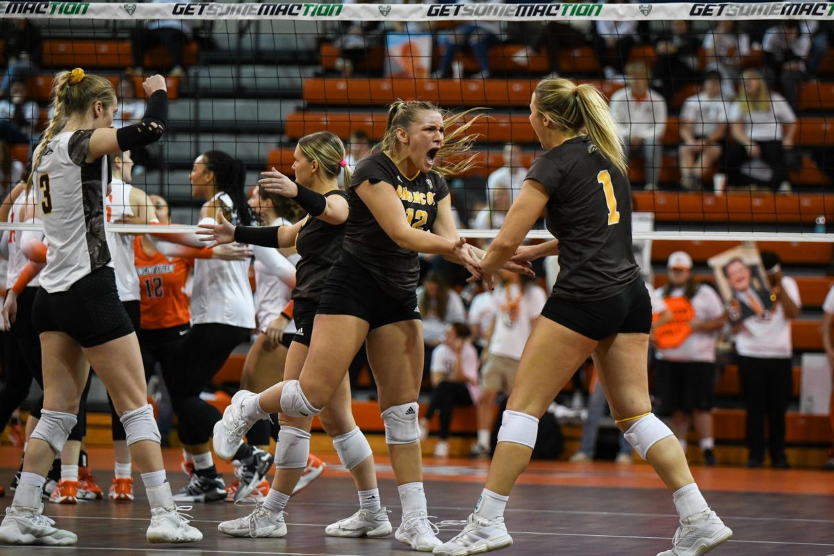 Bowling Green, OH - Broncos fifth year setter Logan Case (12) and senior middle blocker Madison Merz (1) celebrating taking a point from the Falcons at the Stroh Center in Bowling Green, Ohio.