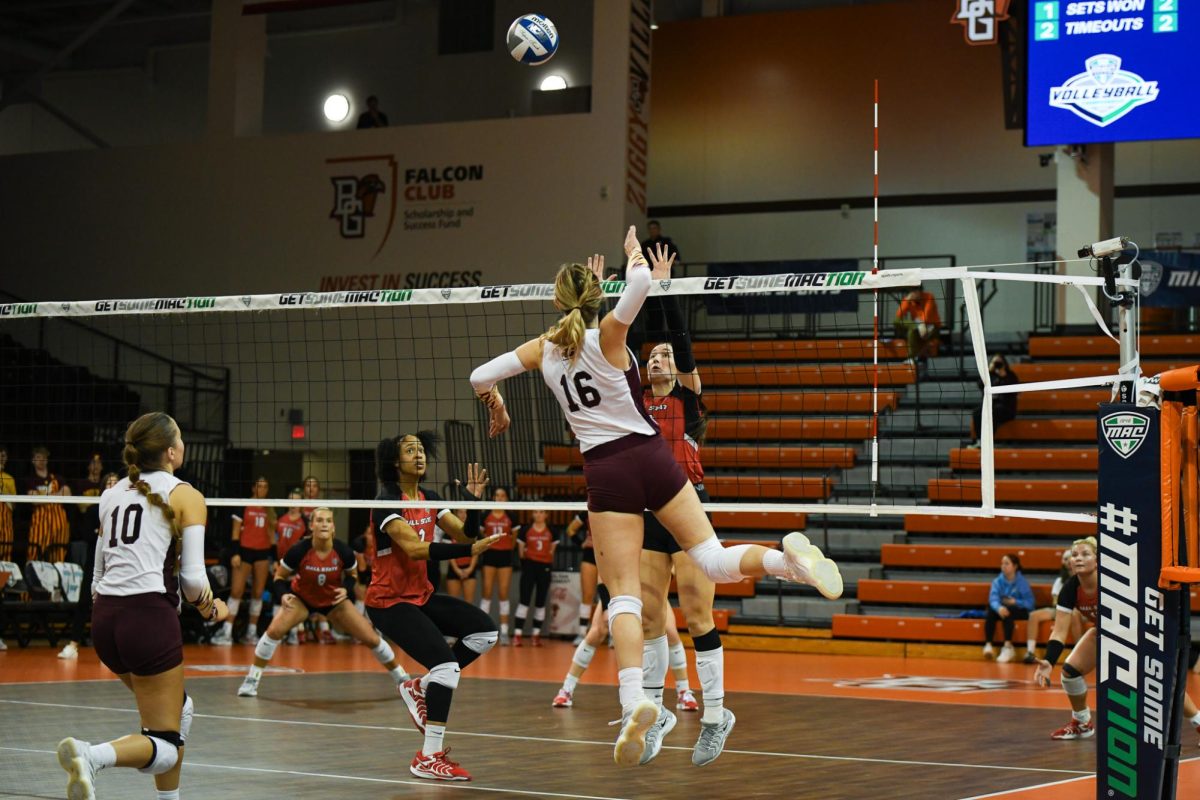 Bowling Green, OH - Chippewas freshman middle blocker Grace Thomas (16) attacking around the Cardinals blocker at the Stroh Center in Bowling Green, Ohio.