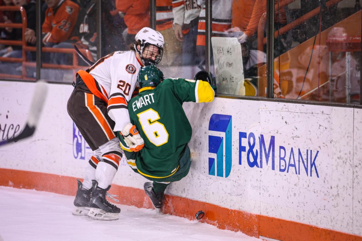 Bowling Green, OH - Falcons senior forward Ryan O'Hara (20) checks Wildcats sophomore defenseman Tynan Ewart (6) at the Slater Family Ice Arena in Bowling Green, Ohio.