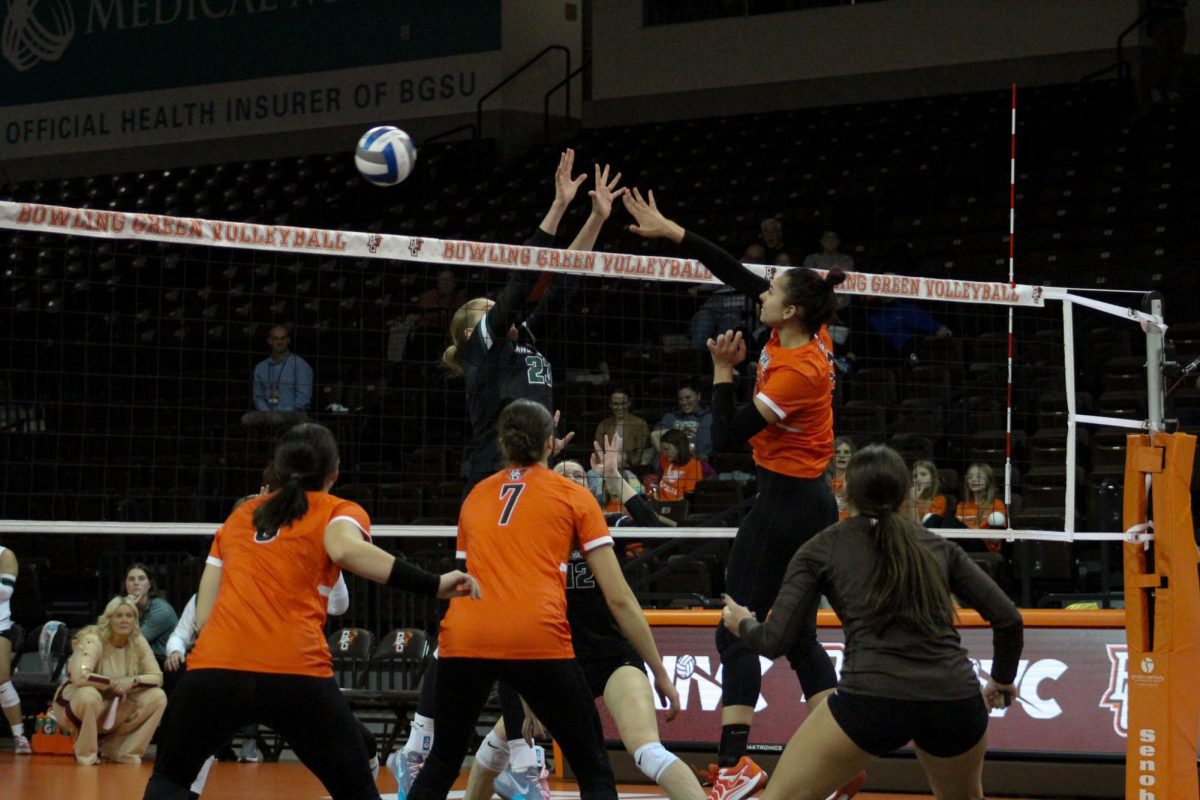 Bowling Green, OH - Falcons sophomore setter Amanda Otten (11) hitting over the Bearcats defense at the Stroh Center in Bowling Green, Ohio.