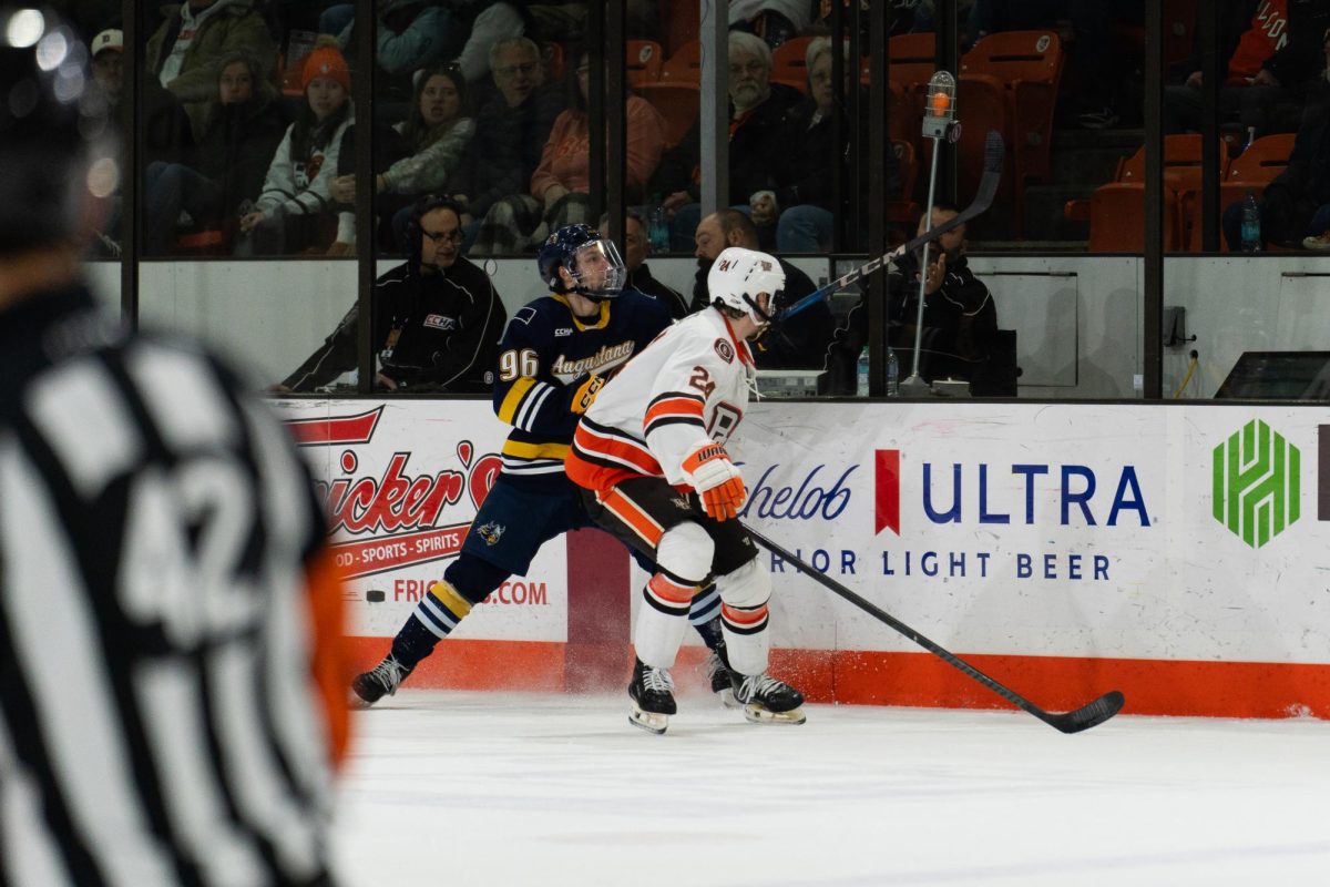 Bowling Green, OH- Falcons junior defender Eric Parker (24) fighting the Vikings for the puck at the Slater Family Ice Arena in Bowling Green, Ohio.