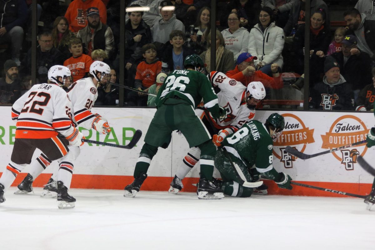 Bowling Green, Ohio- Falcons Junior Forward Jaden Grant (28) is caught in the middle of a fight for the puck against the Beavers.