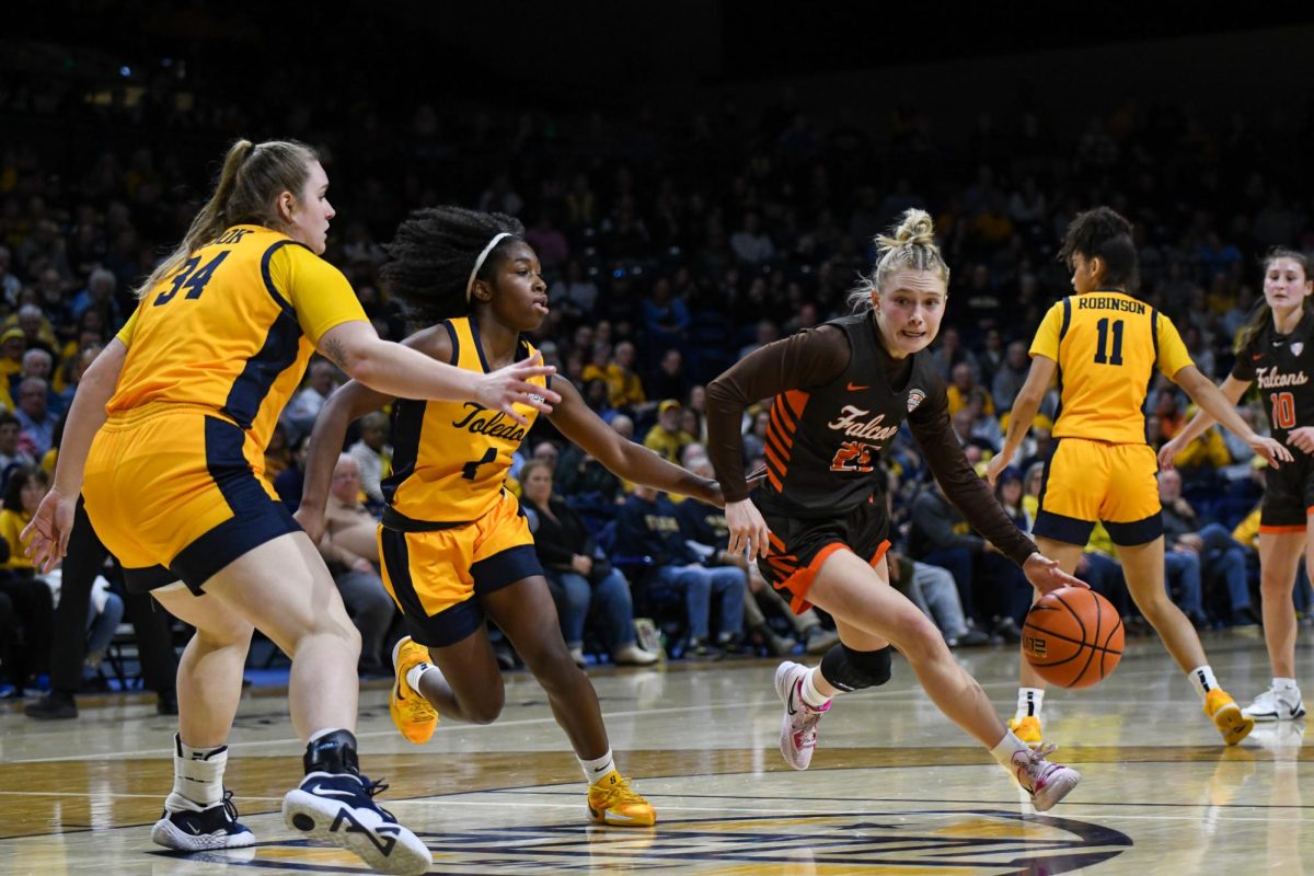 Toledo, OH - Falcons fifth year guard Lexi Fleming (25) driving around the Rockets defense at Savage Arena in Toledo, Ohio.