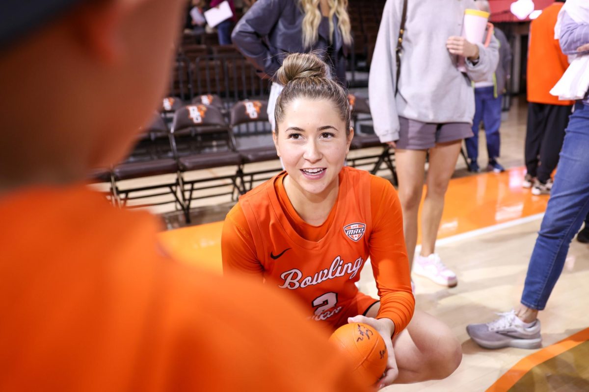 Bowling Green, OH - Junior guard Emily Siesel (2) talks to a fan and signs their ball following Hoops Night at the Stroh Center in Bowling Green, Ohio.