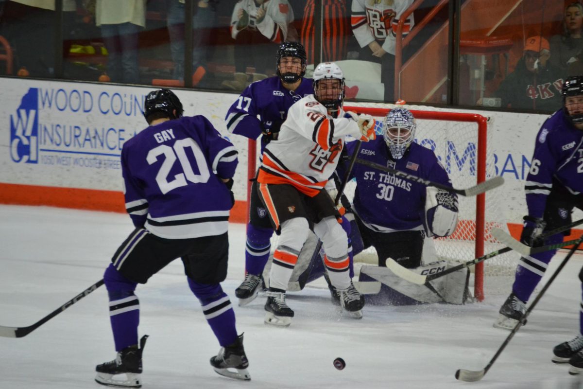 Bowling Green, OH - Falcons junior forward Jaden Grant (28) trying deflect the puck into the goal at Slater Family Ice Arena in Bowling Green, Ohio.