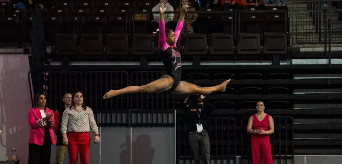 Kayla Shaw leaping through the air during a floor routine