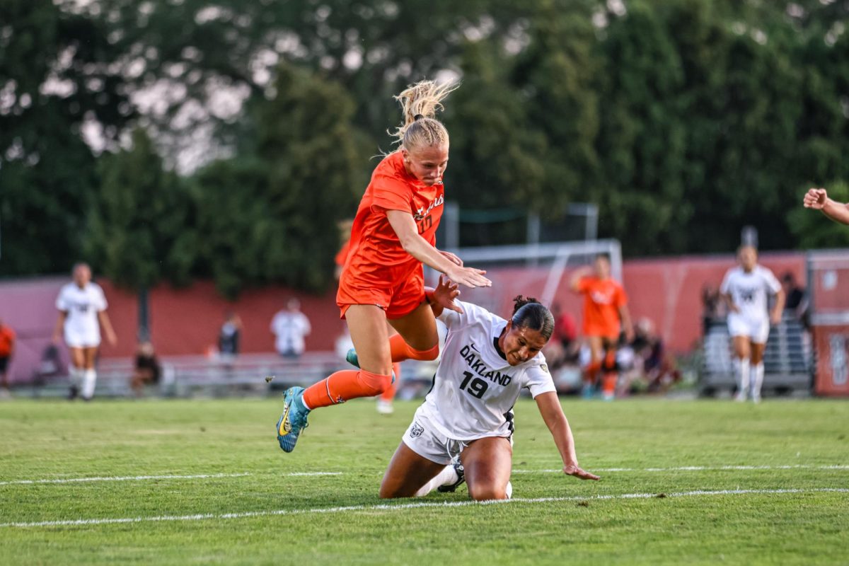 Bowling Green, OH - Falcons junior forward Ella Kane (13) gets caught up with a Golden Grizzly while fighting for possession of the ball at Cochrane Stadium in Bowling Green, Ohio.