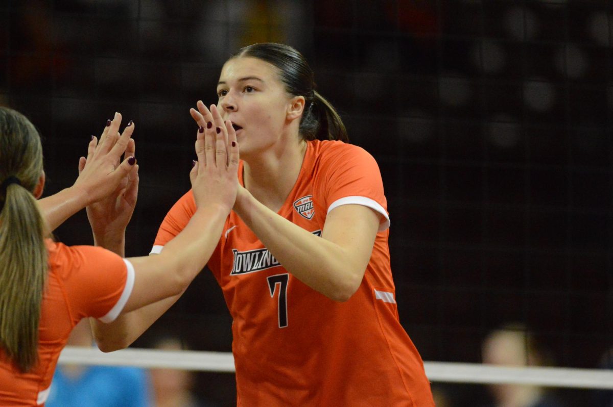 Bowling Green, OH - Falcons senior middle blocker Jessica Andrews (7) high fives a teammate after a serve scored against the Toledo Rockets at the Stroh Center in Bowling Green, Ohio.