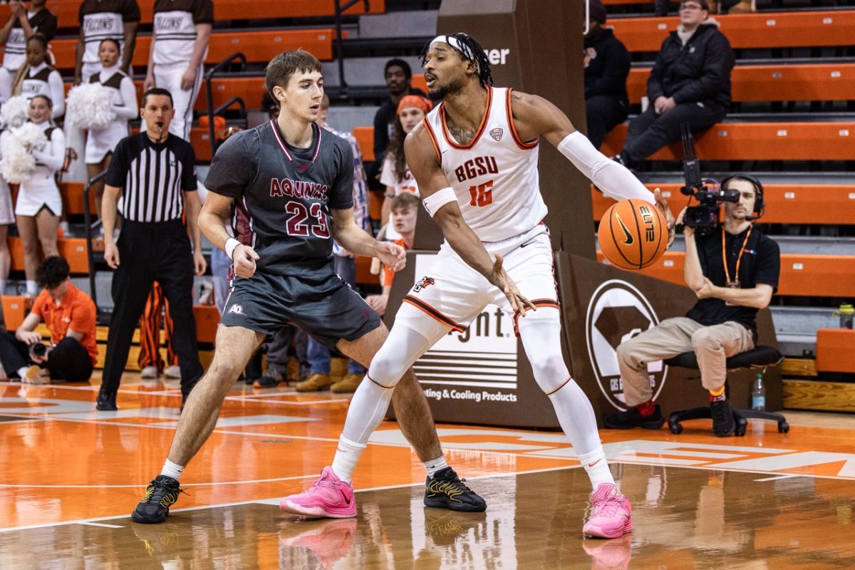 Bowling Green, OH - Falcons senior forward Troy Glover II (16) fights to the rim with Saints redshirt-sophomore forward Caden Pokorzynski (23) during a game between the Aquinas Saints and the Bowling Green Falcons at the Stroh Center in Bowling Green, Ohio.