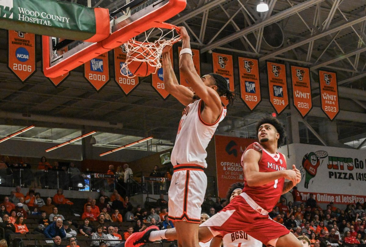 Bowling Green, OH - Falcons senior forward Sam Towns (14) hanging on the hoop while dunking the basketball at the Stroh Center in Bowling Green, Ohio.