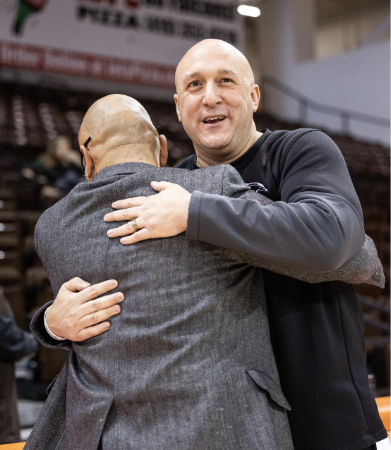 Bowling Green, OH - Falcons head coach Fred Chimel (left) embraces former Falcon assistant coach, and currect Le Moyne head coach, Nick DiPillo, before a game between the Le Moyne Dolphins and the Bowling Green Falcons at the Stroh Center in Bowling Green, Ohio.