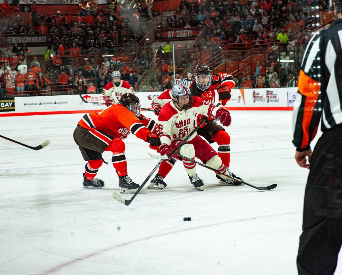 Bowling Green, OH - Buckeyes junior forward Sam Deckhut (25) trying to pass two Falcon defensemen at Slater Family Ice Arena in Bowling Green, Ohio.