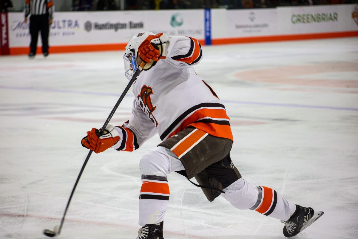 Bowling Green, OH - Falcons freshman defense Brayden Crampton (25) takes a shot on goal during a game between the Bowling Green Falcons and the St. Thomas Tommies at the Slater Family Ice Arena in Bowling Green, Ohio.