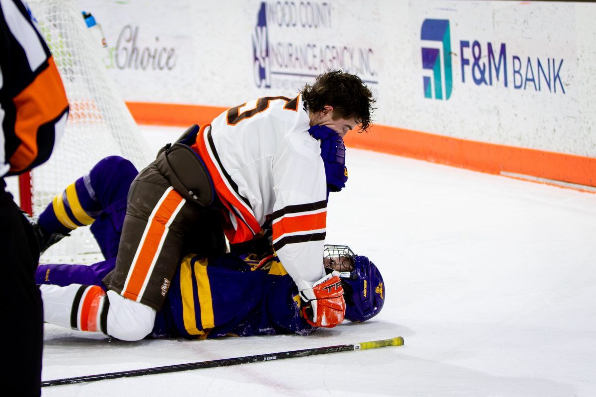 Bowling Green, OH - Falcons freshman defenseman Brayden Crampton (25) body slams and fights Mavericks freshman forward Reid Morich (44) during a game between the Bowling Green Falcons and the Minnesota State Mavericks at the Slater Family Ice Arena in Bowling Green, Ohio.