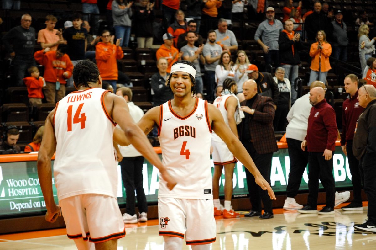 Bowling Green, OH - Falcons sophomore guard Josiah Shackelford (4) embraces fellow teammate Falcons senior forward Sam Towns (14) after a win in a game between the Bowling Green Falcons and the University of Massachusetts Minutemen at the Stroh Center in Bowling Green, Ohio.