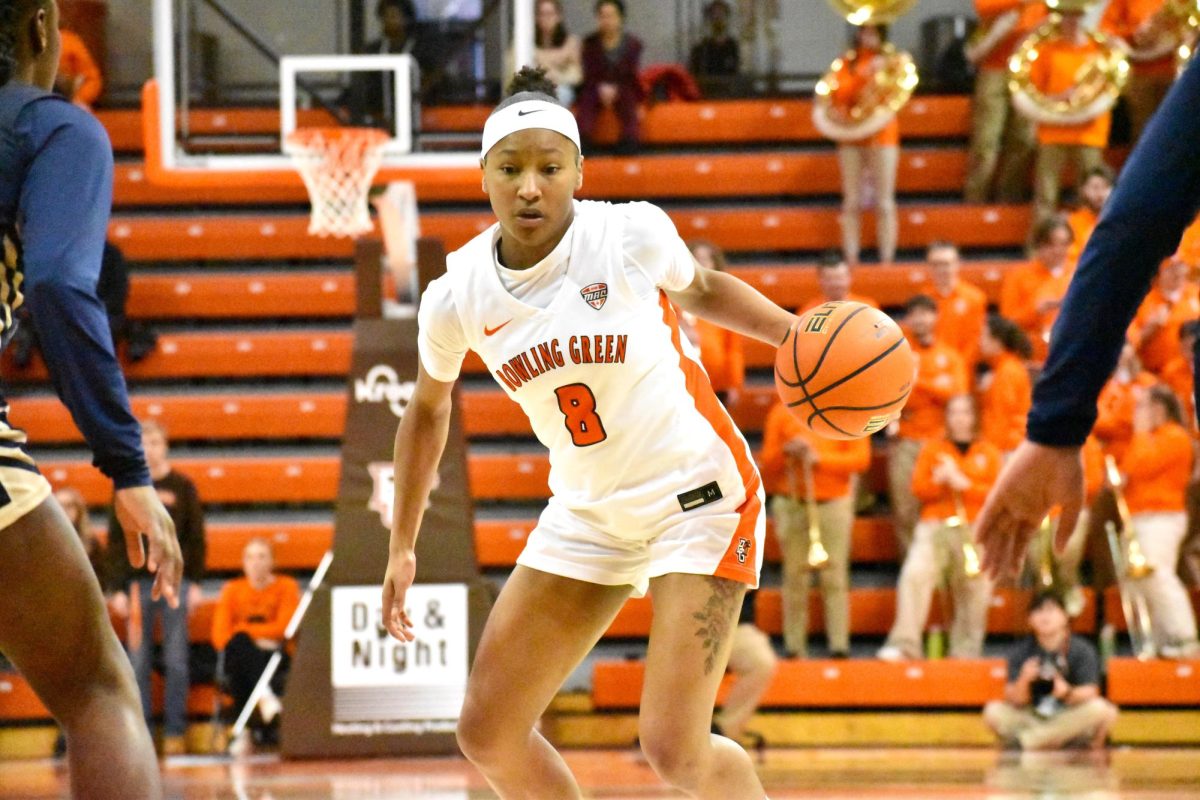 Bowling Green, OH - Falcons junior forward Joniyah Bland-Fitzpatrick (8) dribbles between two Akron Zips defenders during a game at the Stroh Center in Bowling Green, OH.