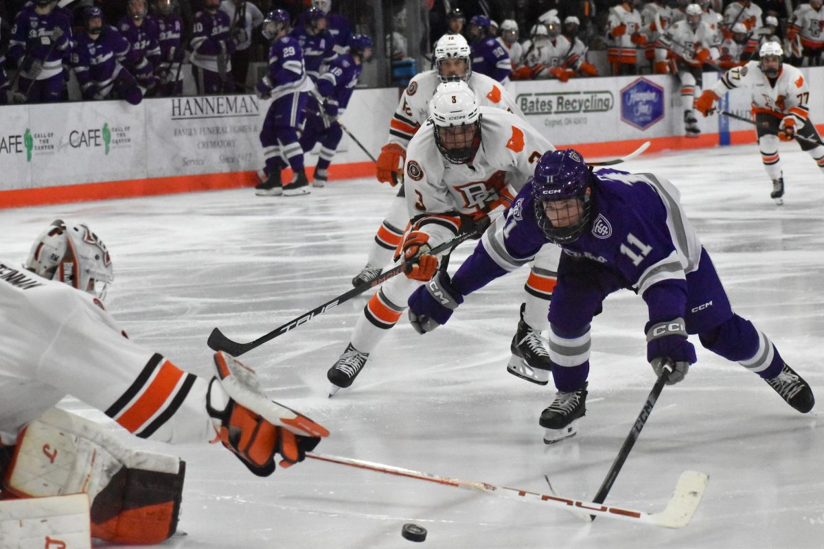 Bowling Green, OH - Tommies senior forward Ryan O'Neill (11) takes a shot on Falcons freshman goalie Jacob Steinman (1) during a match at Slater Family Ice Arena in Bowling Green, Oh