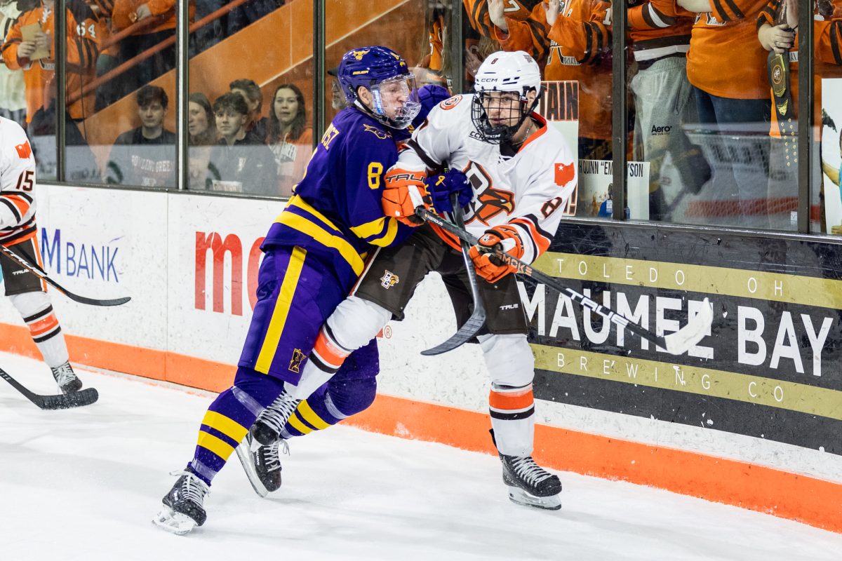Bowling Green, OH - Mavericks senior defenseman Campbell Cichosz (8) and Falcons freshman forward Jérémie Minville (8) wrestle on the boards during a game between the Minnesota State Mavericks and the Bowling Green Falcons at the Slater Family Ice Arena in Bowling Green, Ohio.