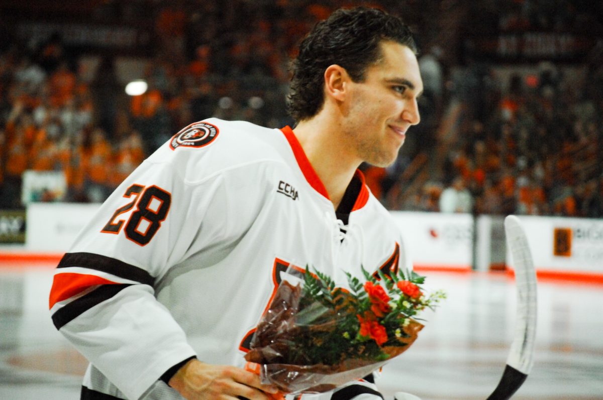 Bowling Green, OH - Falcons senior forward Jaden Grant (28) smiles with a bouquet in hand before a game between the Minnesota State Mavericks and the Bowling Green Falcons at the Slater Family Ice Arena in Bowling Green, Ohio.